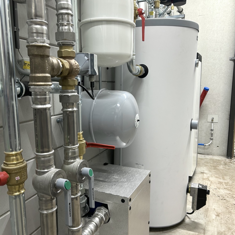 Warmtepompinstallatie met leidingwerk en expansievaten in een technische ruimte