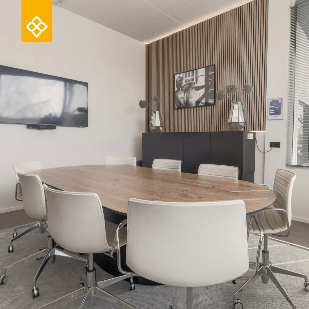 Vergaderruimte met ronde tafel en witte stoelen