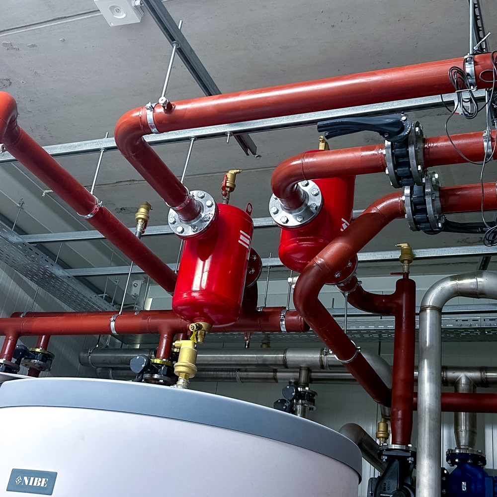 Rode verwarmingsleidingen met appendages in een technische ruimte