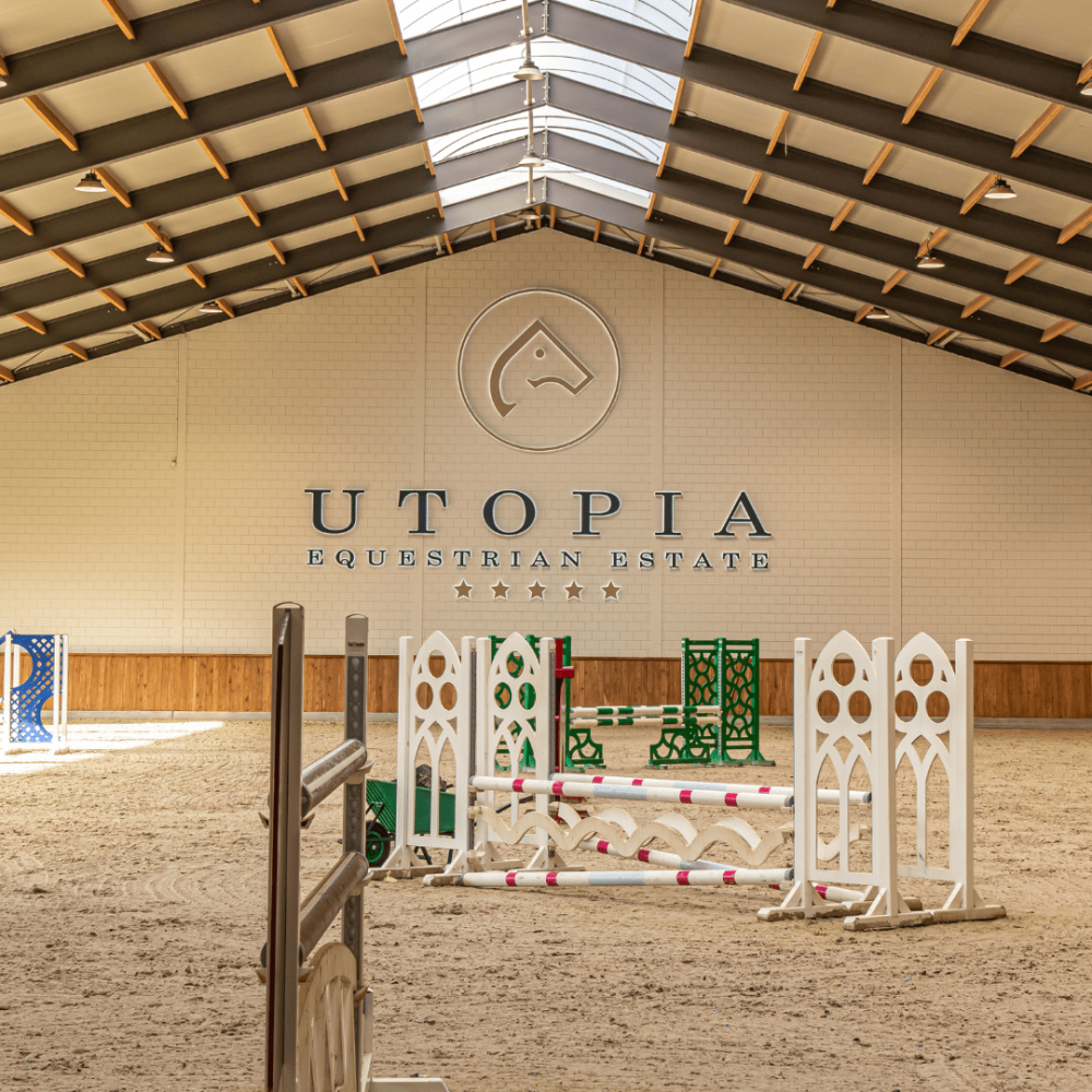 Binnenrijbaan van Utopia Equestrian Estate met springhindernissen