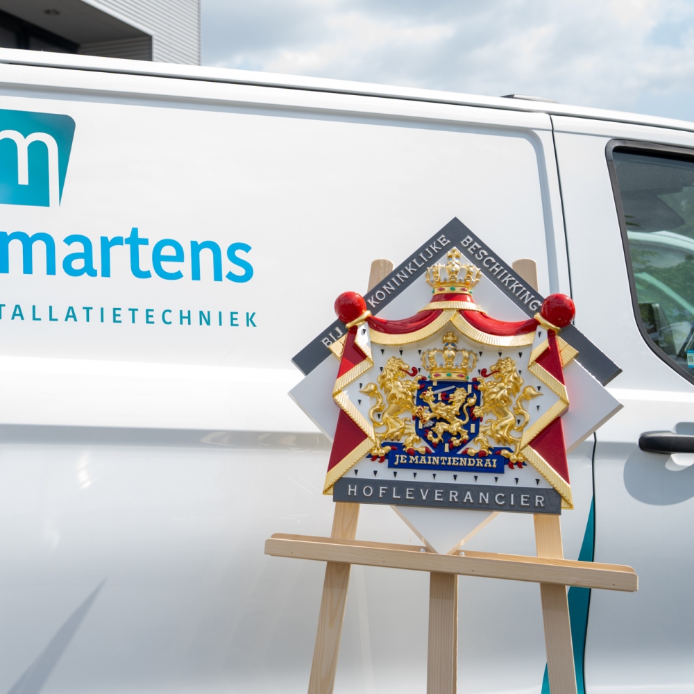 Wapenbord van het predicaat Hofleverancier bij een bedrijfsbus van Keijsers Martens