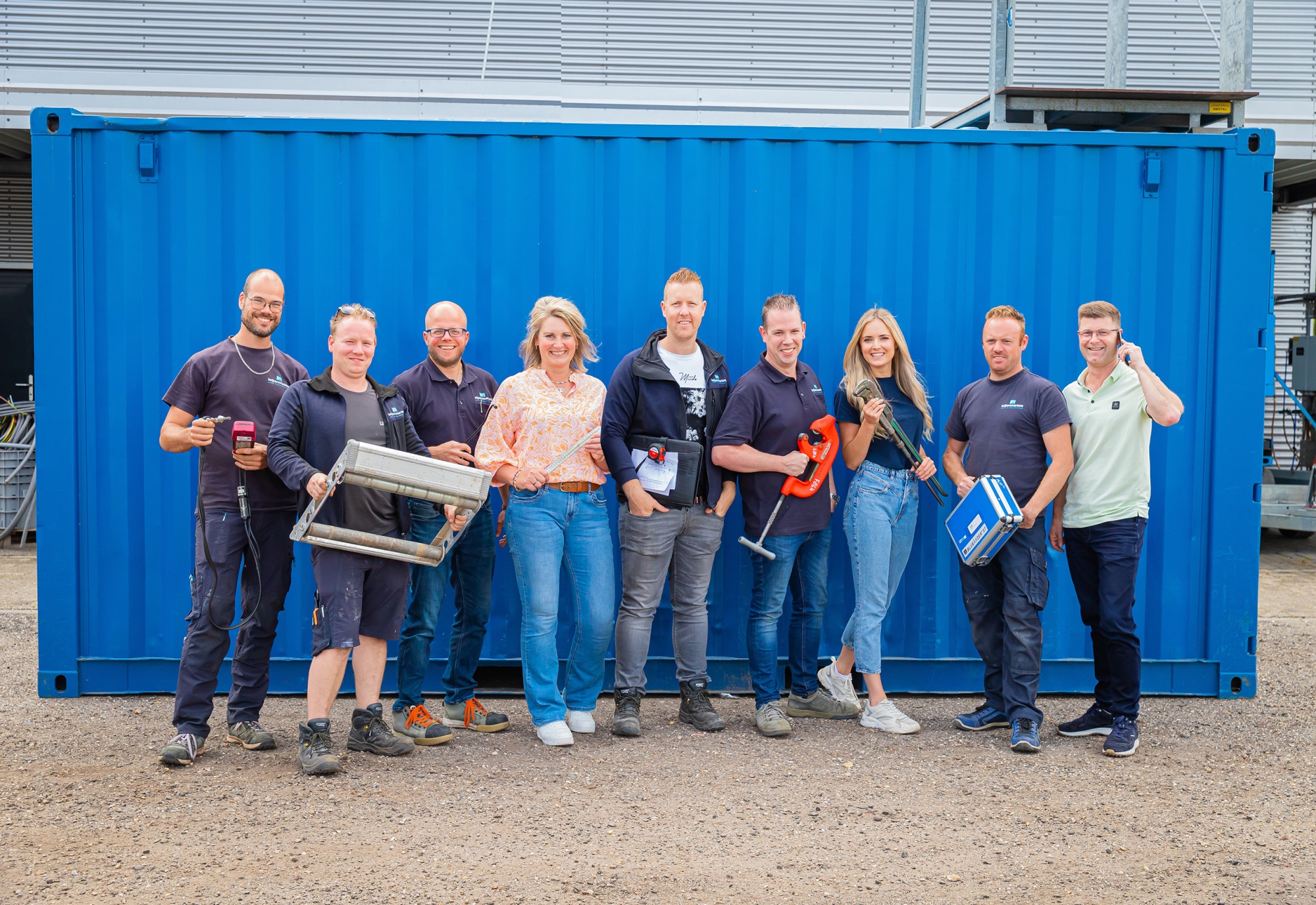 Team van Keijsers Martens met gereedschap voor een blauwe container