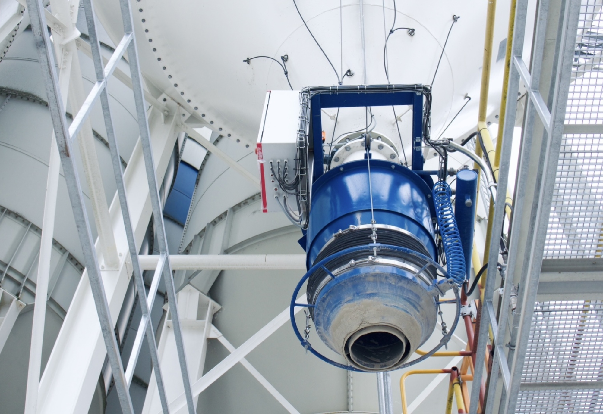 Industriële installatie met blauwe ventilator in een stalen constructie